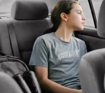 Joven deportista viajando en el asiento trasero de un coche durante el trayecto de vuelta, Papás Uber